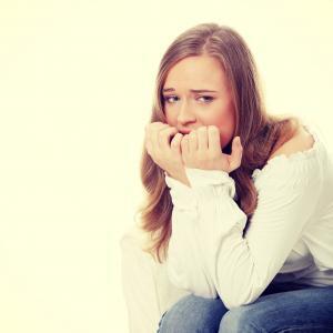 Stressed young woman eating her nails